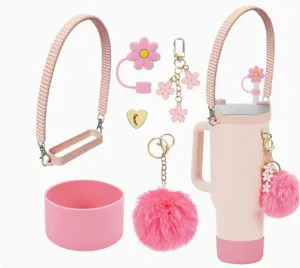 Pink tumbler accessory set including silicone boot, strap, flower straw cover, and cute charms.