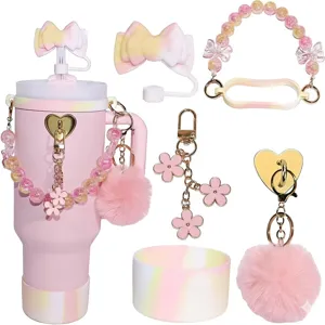Pink insulated tumbler accessories set with cute bow straw topper and pom pom chain details.