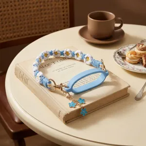 Detail view of woven daisy cup strap with blue silicone ring and cute floral charm.