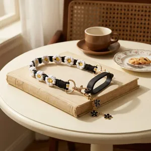 Handcrafted black and white daisy woven water bottle strap with silicone ring and cute charms.