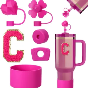 Pink Stanley cup accessories set featuring silicone straw covers, initial charm and protective boot.