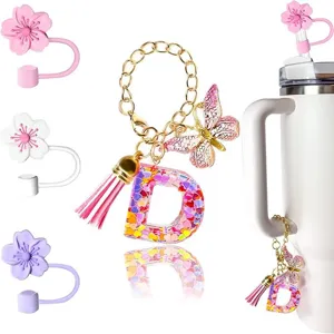 Portachiavi con lettera D in resina glitterata con farfalla e copripaglia a fiore.