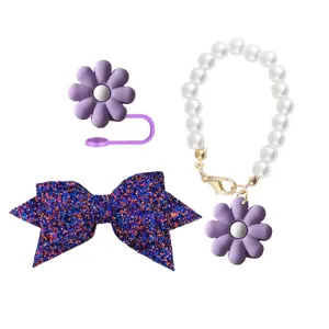 Stanley cup charm detail view featuring purple silicone flower straw topper, pearl chain, and bow.