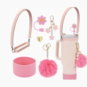 Pink tumbler accessories set with silicone boot, flower straw cover, strap and fluffy pom pom.
