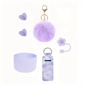 Purple tumbler accessories set including pom-pom keychain, silicone boot, and straw cover.