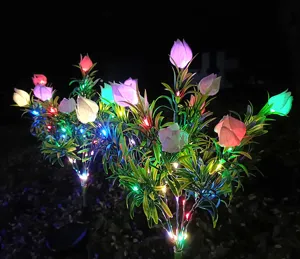 Nächtlicher Blick auf bunte Solar-Gartenblumenleuchten im Freien, die Hof und Rasen beleuchten.