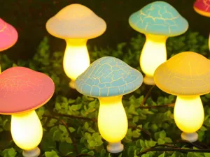 Gros plan detaille de lumieres decoratives LED de champignons craqueles dans le feuillage.