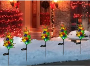 Gros plan sur les détails des lampes solaires LED en forme de sapin dans la neige.
