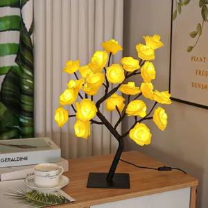 Vue détaillée de la lampe lumineuse en forme de branche de rosier jaune à l'ambiance chaleureuse.