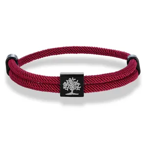 Detailed view of red woven rope bracelet showcasing black metal square bead with tree motif.
