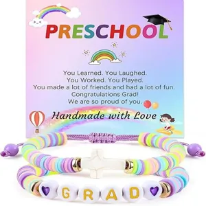 Close-up detail of colorful clay bead graduation bracelets with cross and letter charms.