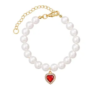 Cute pearl dog collar necklace with red crystal heart pendant and gold extender for small pets.
