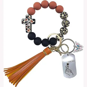 Détail de porte-clés bracelet en perles de silicone avec perles léopard, pompon et pendentif.
