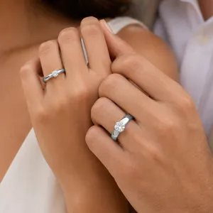 Elegante minimalistische silberne Solitär Diamant Paarringe Detailaufnahme glänzend.