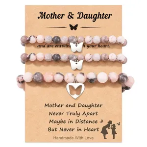 Mother daughter beaded bracelet detail, pink zebra stone with butterfly charms on display card.