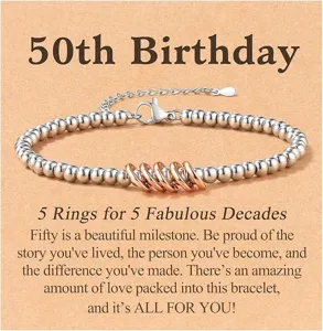 Detail shot of women silver beaded bracelet with five rose gold rings for 50th birthday.