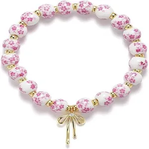 Ceramic floral beaded stretch bracelet with gold bow pendant for women friendship jewelry