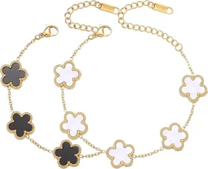 Close-up detail shot of golden titanium steel bracelets with black and white clover charms.