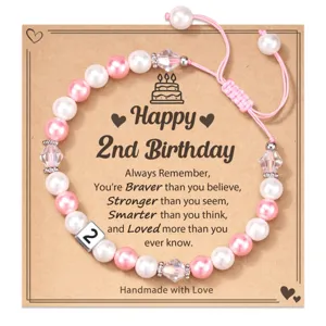 Detailed view of handmade pink and white pearl 2nd birthday bracelet with number 2 bead card.