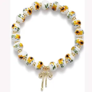 Sunflower ceramic beaded bracelet with golden bow pendant elegant elastic friendship jewelry main