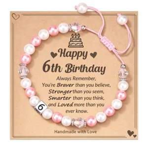 Detailed view of the 6th birthday beaded bracelet with pink and white pearls and number 6.