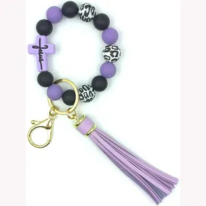 Détail de porte-clés en perles de silicone avec perles léopard et pompon violet élégant.