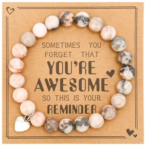 Detail shot of natural stone beaded bracelet with heart charm on inspirational kraft card.