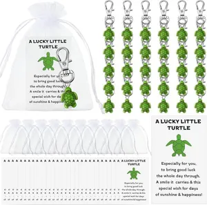 Turtle keychain set with white organza bags and blessing cards for party favors.