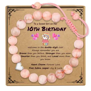 Detailed close-up of pink zebra jasper beaded bracelet with silver heart charm and gift card.