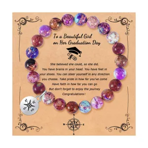 Primer plano detallado de pulsera de cuentas de piedra natural con dije de brújula de graduación.