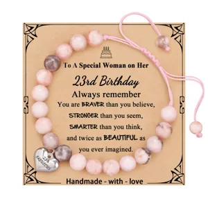 Detailed view of the beaded birthday bracelet with card, featuring pink stones and heart charm.