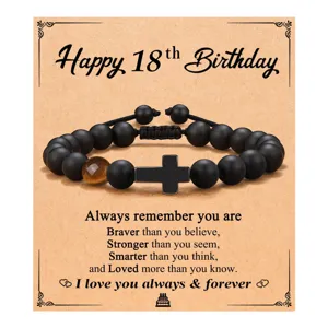 Pulsera de cuentas negras mate con cruz y ojo de tigre en tarjeta de felicitación