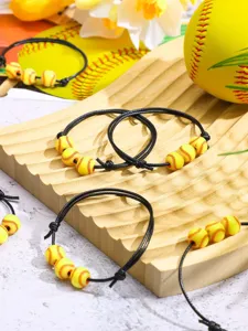 Soft clay sports beaded bracelets detail showcasing black cords and yellow softball beads.