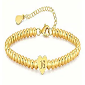 Detail view of a gold-plated beaded bracelet with a number 16 heart charm and adjustable chain.