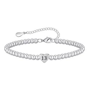 Silver beaded bracelet detail shot showing the heart shaped charm with number 13.