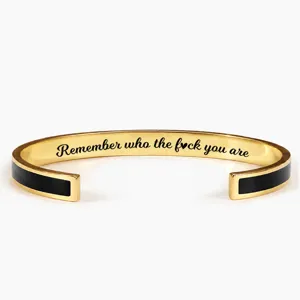 Stainless steel open cuff bracelet with black enamel inlay and engraved motivational quote.