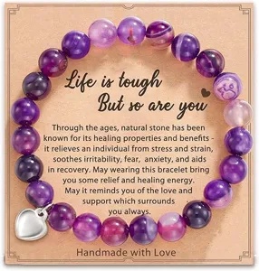 Detailed view of the purple agate beaded bracelet with a silver heart charm on display card.