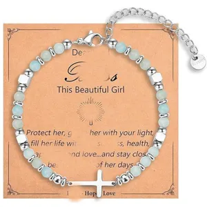 Beaded bracelet with cross pendant and natural stone beads, bohemian style jewelry detail.
