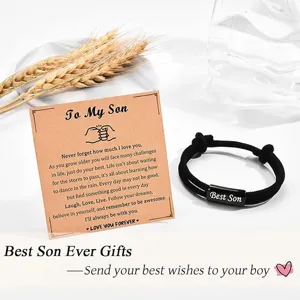 Close-up detail of black braided cord bracelet for son with message card and metallic tag.