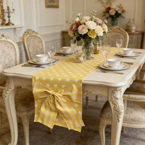 Gelber Tischläufer mit Herz-Muster und eleganter gestreifter Schleife für schöne Dekoration.