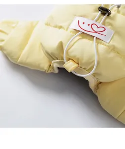Close-up detail of yellow pet down dog jacket showing adjustable drawstring and cute embroidered label.