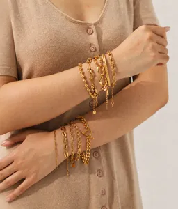 Close-up detail of multi-layer gold-plated stainless steel chain bracelets set for women.