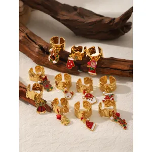 Close-up details of Christmas themed gold stainless steel rings with enamel cartoon pendants.