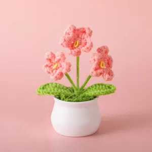 Detailed view of the handmade crochet pink flower potted plant, showing exquisite yarn texture.