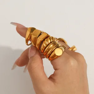 Gold chunky stacking rings detail shot, geometric signet and twisted band finger jewelry style.