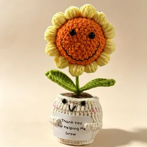 Closeup crochet sunflower potted plant, handmade knitted flower toy detail with cute smiling face.