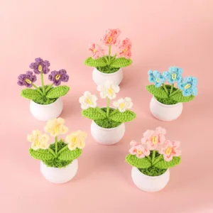 Handmade crochet floral potted plant detail, cute wool flower decor for desktop and home display.