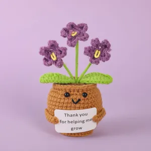 Handmade crochet potted plant detail closeup, cute knitted emotional expression doll for decor.