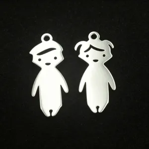 Gros plan de pendentifs garcon et fille en acier inoxydable pour fabrication de bijoux.