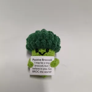 Vista detallada de peluche de brócoli de ganchillo hecho a mano, muñeco con tarjeta.
